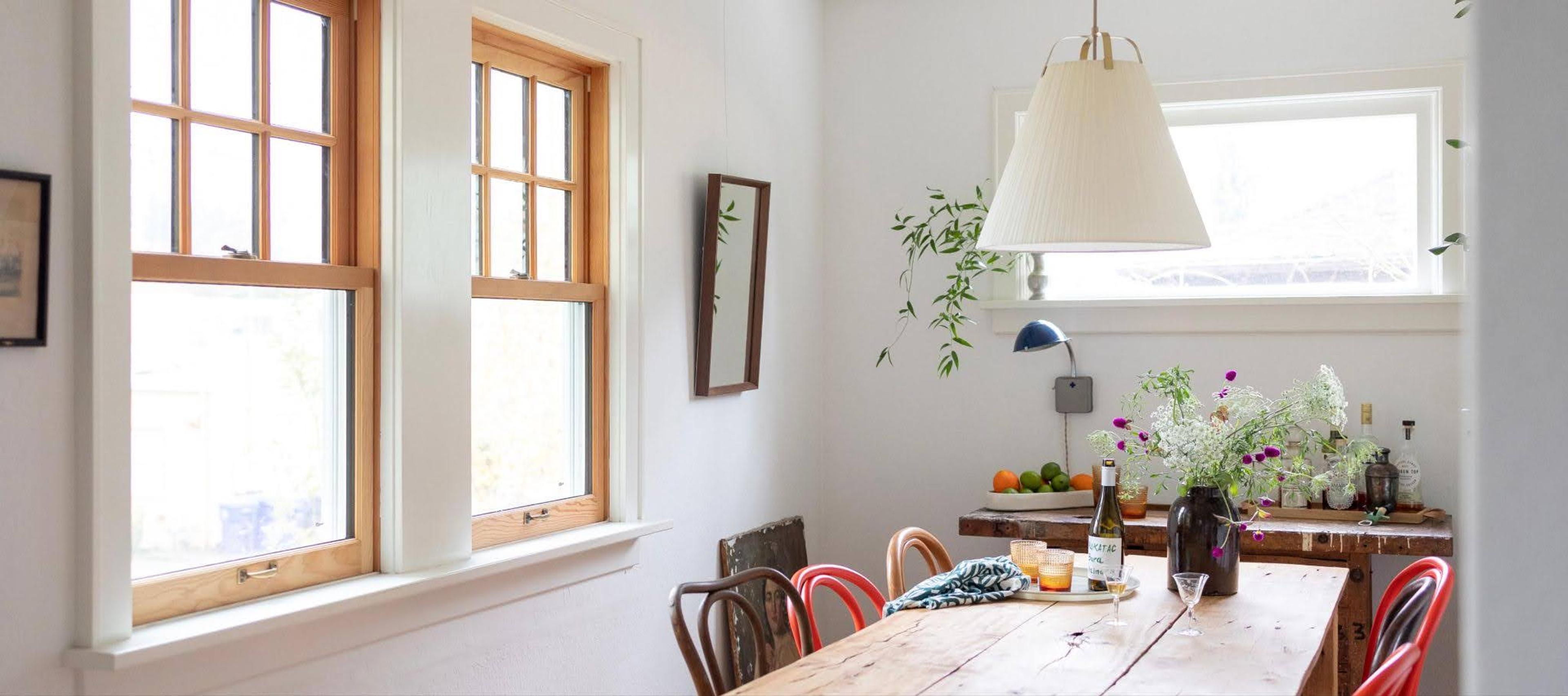 Dining table in a room with a lot of windows
